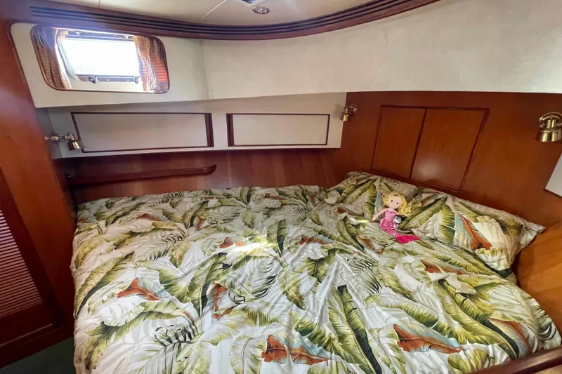 Slide: The Image of Cozy bedroom in 2002 President Trawler with tropical bedding and a doll. - 62
