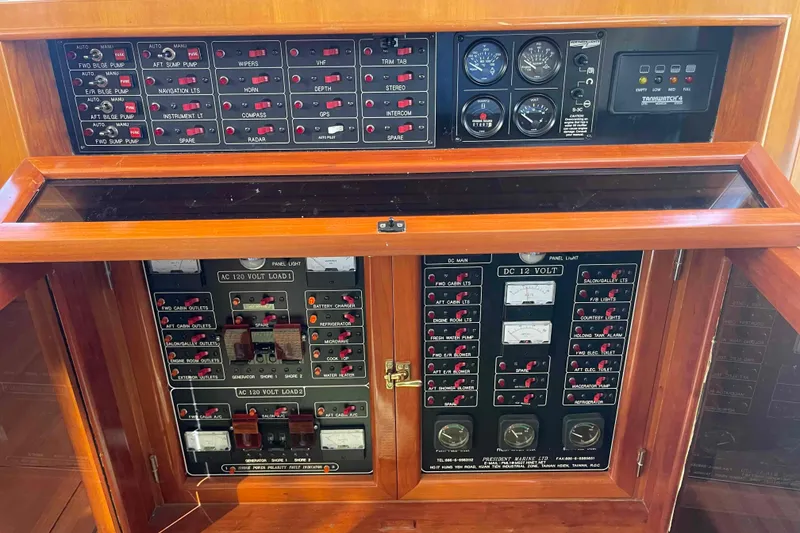Slide: The Image of Electrical control panel on a 2002 President Trawler boat, featuring various switches and gauges. - 45