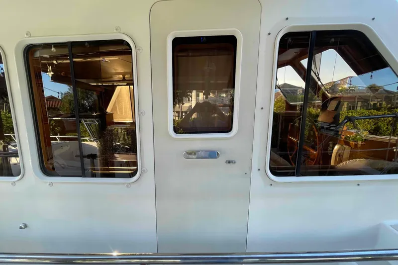 Slide: The Image of 2002 President Trawler yacht exterior with windows and door, showcasing interior reflections. - 31