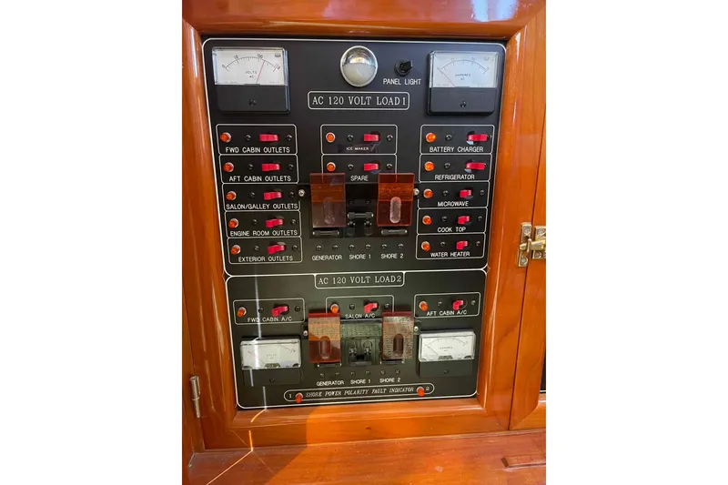 Slide: The Image of Electrical control panel on a 2002 President Trawler boat, featuring various switches and meters. - 43
