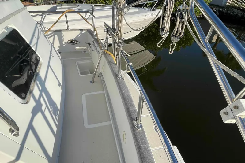 Slide: The Image of 2002 President Trawler boat deck with railing, docked near calm water. - 24