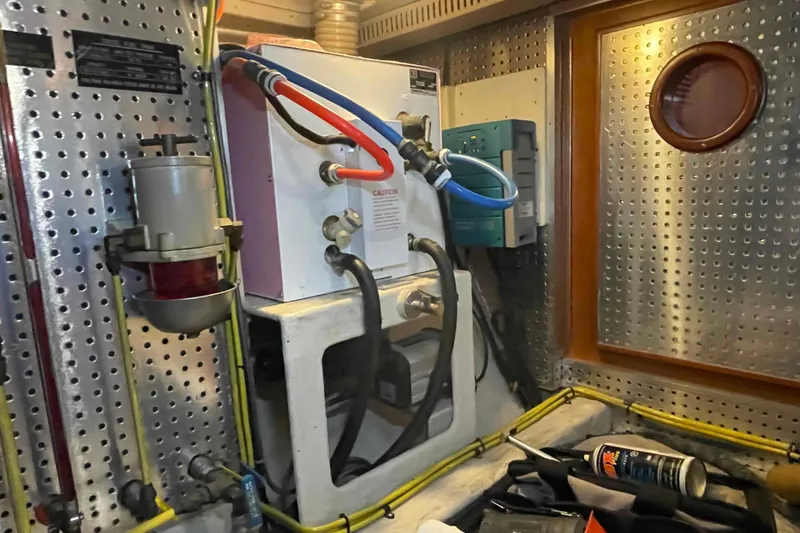 Slide: The Image of Engine room of a 2002 President Trawler with mechanical components and wiring. - 87