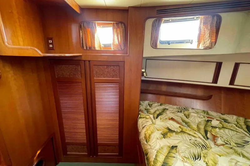Slide: The Image of Cozy cabin interior of 2002 President Trawler with wooden finishes and patterned bedding. - 61