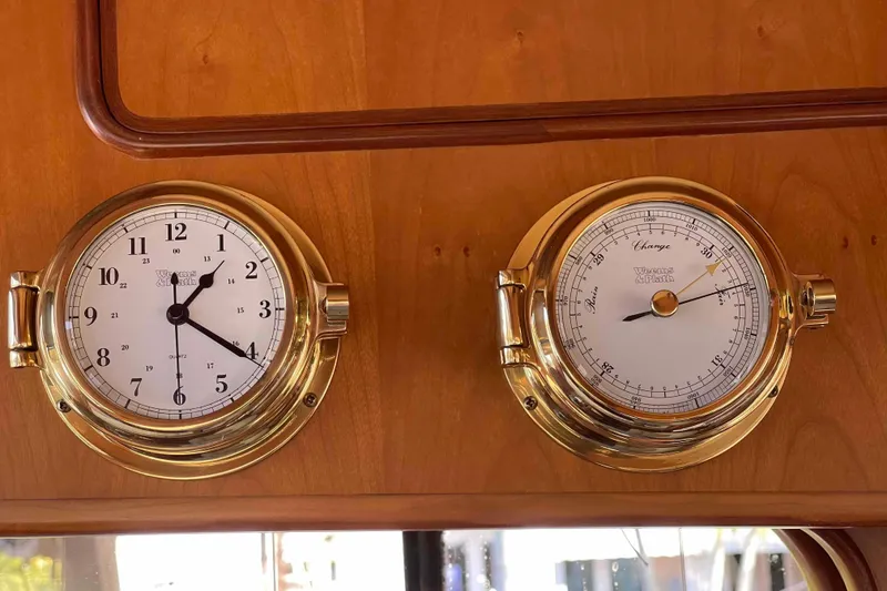 Slide: The Image of Brass clock and barometer on 2002 President Trawler's wooden interior. - 49