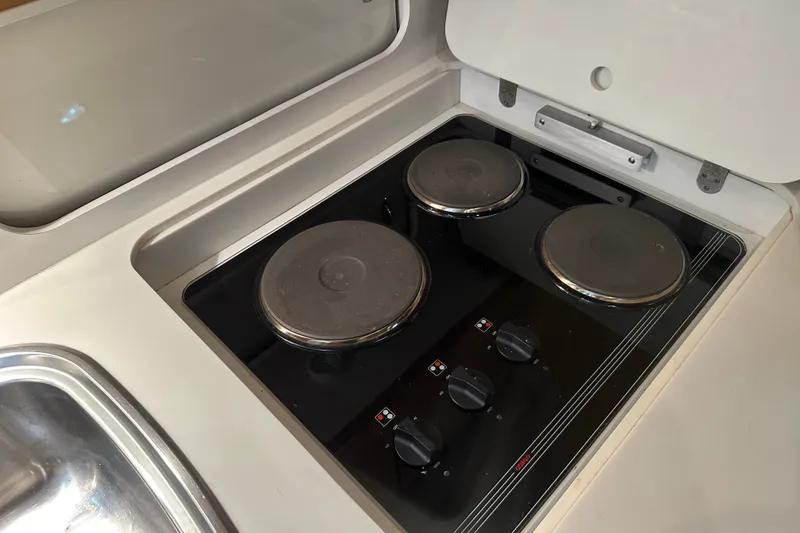 Slide: The Image of Stovetop in 1997 Tiara Yachts 4000 Express galley, featuring three burners and control knobs. - 25