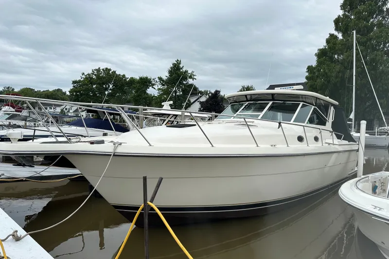 Slide: The Image of 1997 Tiara Yachts 4000 Express docked at marina under cloudy sky. - 7