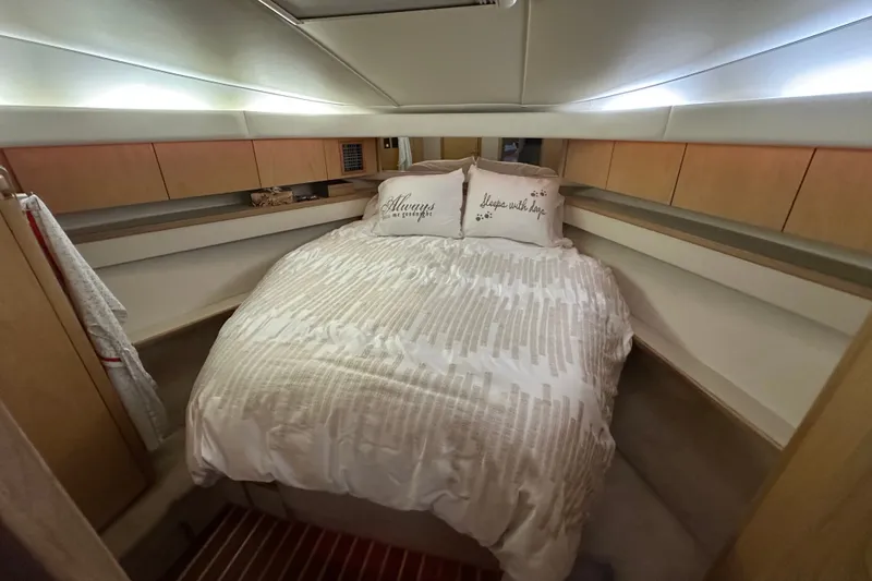 Slide: The Image of Cozy bedroom in 1997 Tiara Yachts 4000 Express with elegant bedding and ambient lighting. - 30