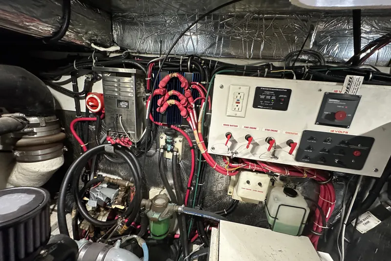 Slide: The Image of Engine room of a 1997 Tiara Yachts 4000 Express, showcasing electrical panels and wiring. - 54