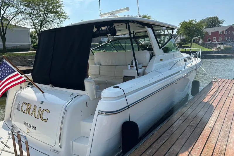 Slide: The Image of 1997 Tiara Yachts 4000 Express docked, featuring sleek design and American flag. - 5