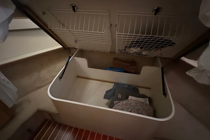 Slide: The Image of Storage compartment in a 1997 Tiara Yachts 4000 Express, featuring organized shelving and clothing. - 32