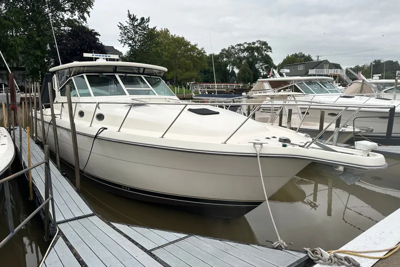 Slide: The Image of 1997 Tiara Yachts 4000 Express docked at a marina, surrounded by other boats. - 6