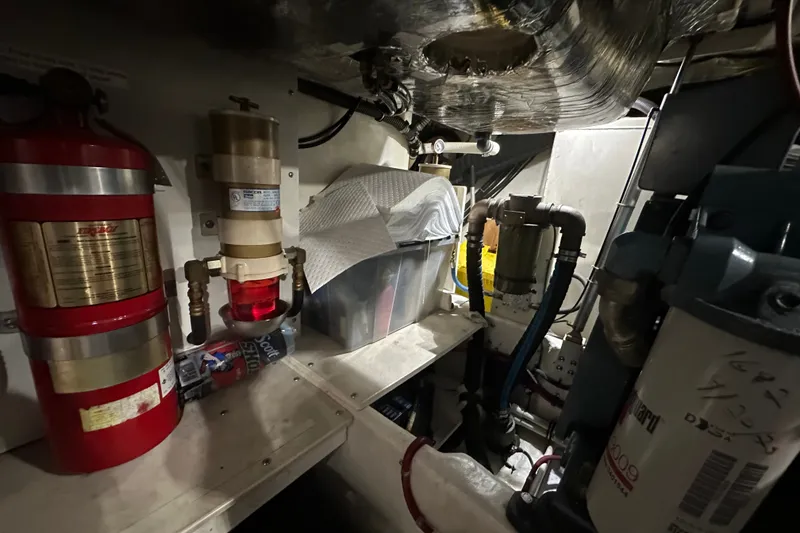Slide: The Image of Engine room of a 1997 Tiara Yachts 4000 Express, featuring fire extinguisher and filtration systems. - 51