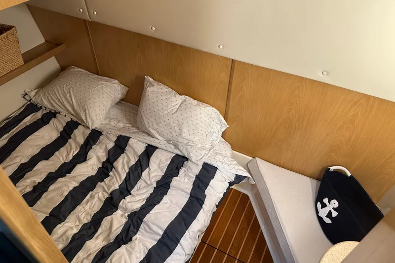 Slide: The Image of Cozy cabin interior of 1997 Tiara Yachts 4000 Express with striped bedding and anchor-themed decor. - 26