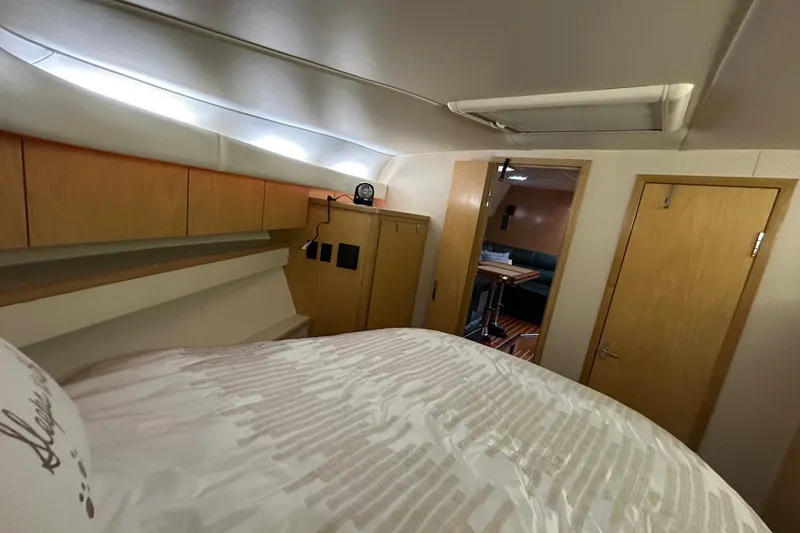 Slide: The Image of Interior cabin of a 1997 Tiara Yachts 4000 Express, featuring wood cabinetry and cozy bedding. - 31