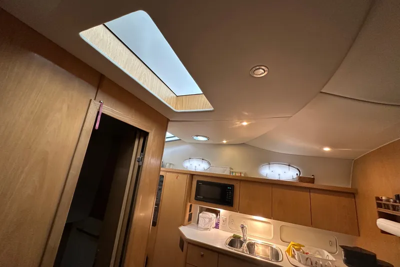 Slide: The Image of Interior of 1997 Tiara Yachts 4000 Express, featuring a modern kitchen area with skylight. - 36