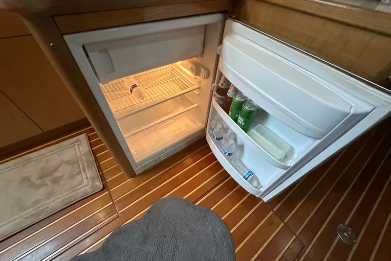 Slide: The Image of Open refrigerator in 1997 Tiara Yachts 4000 Express, stocked with drinks on wooden flooring. - 33