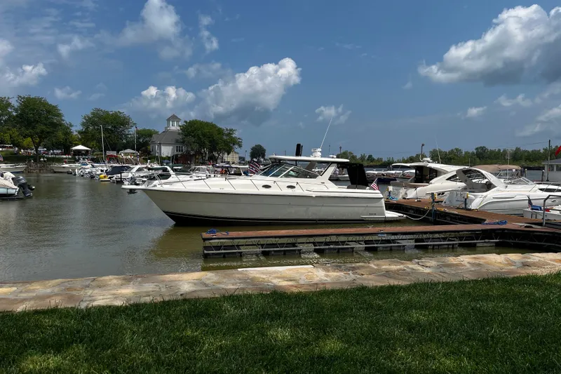 The Image of 1997 Tiara Yachts 4000 Express docked at a marina under a clear blue sky. - 0