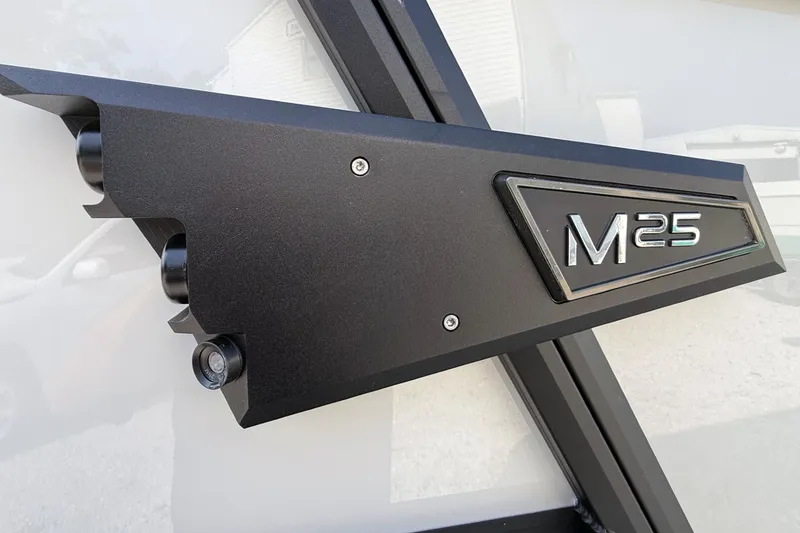 Slide: The Image of Close-up of 2027 Alera M25L model emblem on a sleek black surface. - 3