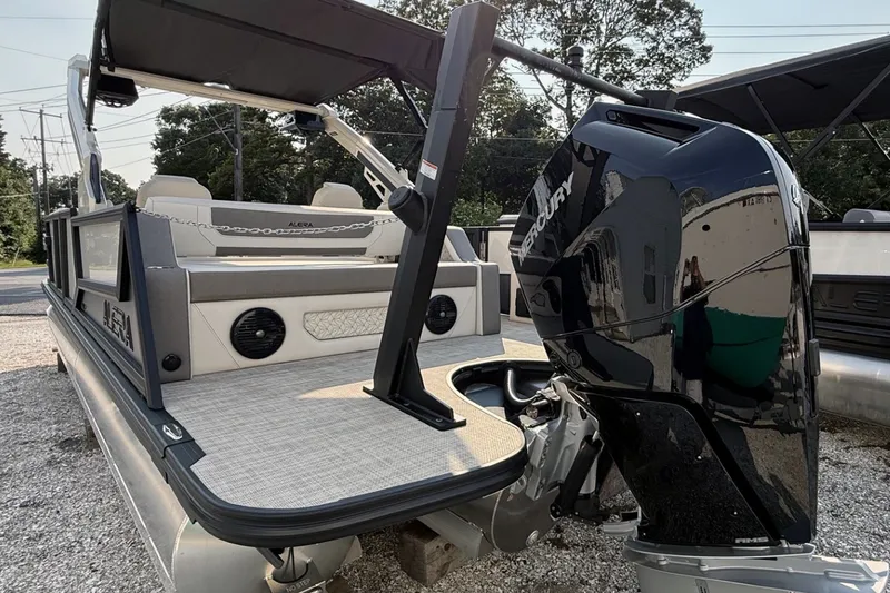 Slide: The Image of Alera M25L 2027 pontoon boat with Mercury outboard motor, docked on gravel. - 7