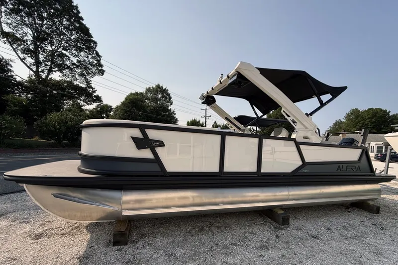 Slide: The Image of 2027 Alera M25L pontoon boat with sleek design and black canopy. - 1