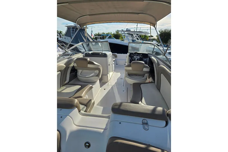 Slide: The Image of 2011 Yamaha Boats 242 Limited interior with seating and helm, docked at marina. - 5