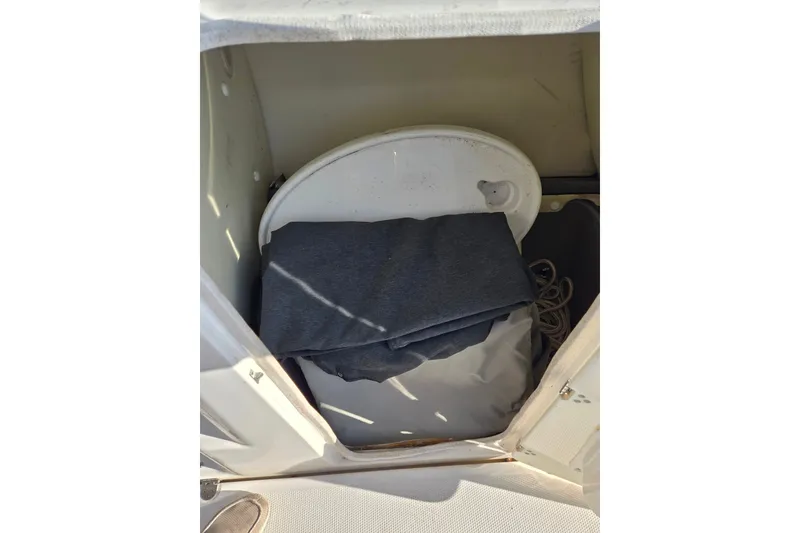 Slide: The Image of Storage compartment in a 2011 Yamaha Boats 242 Limited, containing folded fabric and rope. - 10