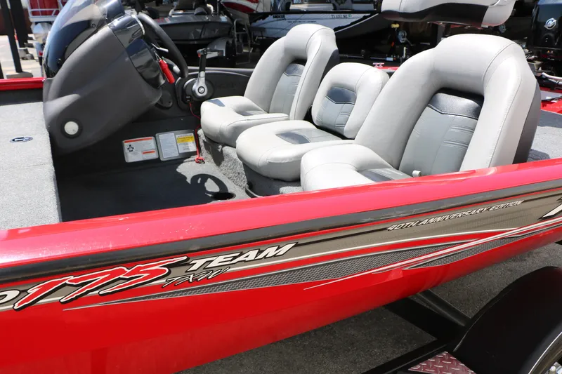 Slide: The Image of 2018 Tracker Pro Team 175 TXW boat interior with gray seats and red exterior. - 17