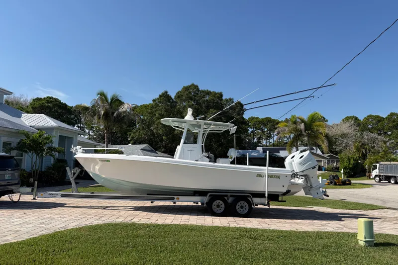 Slide: The Image of 2024 Bluewater BW 25T boat on trailer in residential driveway, sunny day. - 18