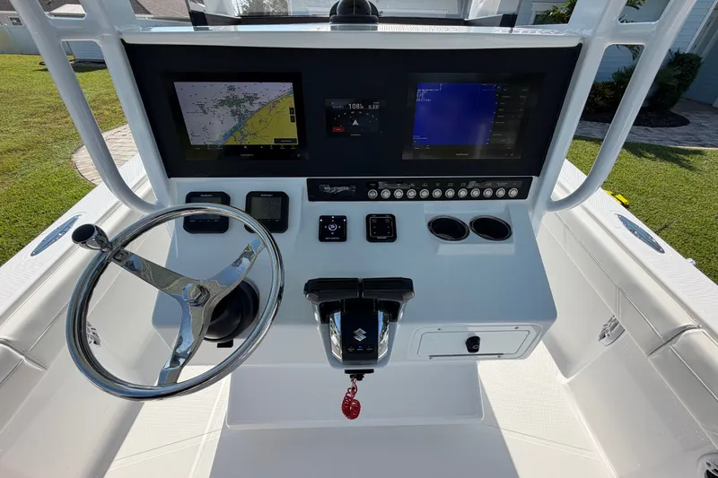 Slide: The Image of 2024 Bluewater BW 25T boat console with steering wheel, navigation screens, and controls. - 27