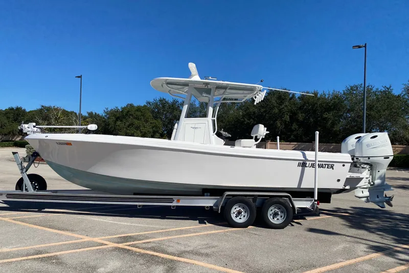 The Image of 2024 Bluewater BW 25T boat on trailer in sunny parking lot. - 0
