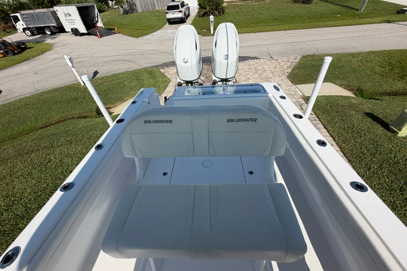 Slide: The Image of 2024 Bluewater BW 25T boat with dual engines, parked on a driveway. - 25