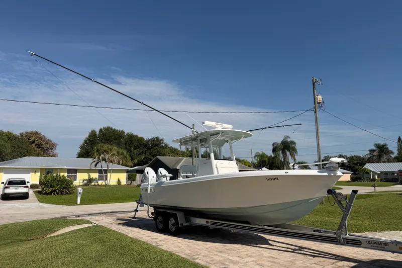 Slide: The Image of 2024 Bluewater BW 25T boat on trailer in suburban neighborhood driveway. - 21