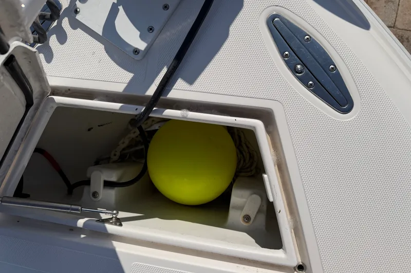 Slide: The Image of Open storage compartment on 2024 Bluewater BW 25T boat with yellow buoy inside. - 34