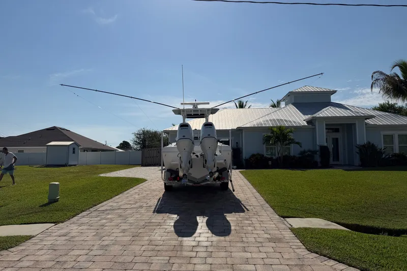 Slide: The Image of 2024 Bluewater BW 25T boat on driveway in front of modern house, sunny day. - 20