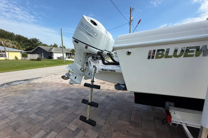 Slide: The Image of 2024 Bluewater BW 25T boat with Suzuki outboard motor on a driveway. - 62