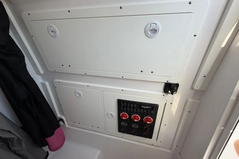 Slide: The Image of 2024 Bluewater BW 25T boat interior control panel with storage compartments. - 55