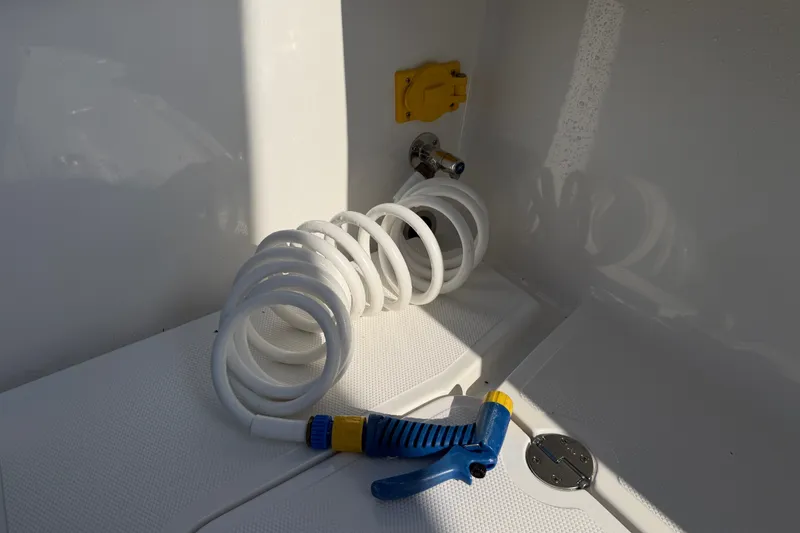 Slide: The Image of Coiled hose and nozzle on 2024 Bluewater BW 25T boat deck. - 45