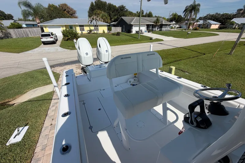 Slide: The Image of 2024 Bluewater BW 25T boat with dual engines, parked in a residential driveway. - 22