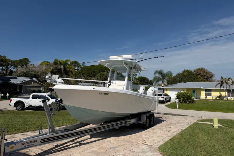 Slide: The Image of 2024 Bluewater BW 25T boat on trailer in suburban driveway, clear sky background. - 17