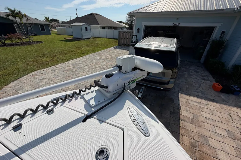 Slide: The Image of 2024 Bluewater BW 25T boat with trolling motor in driveway, near garage and lawn. - 31