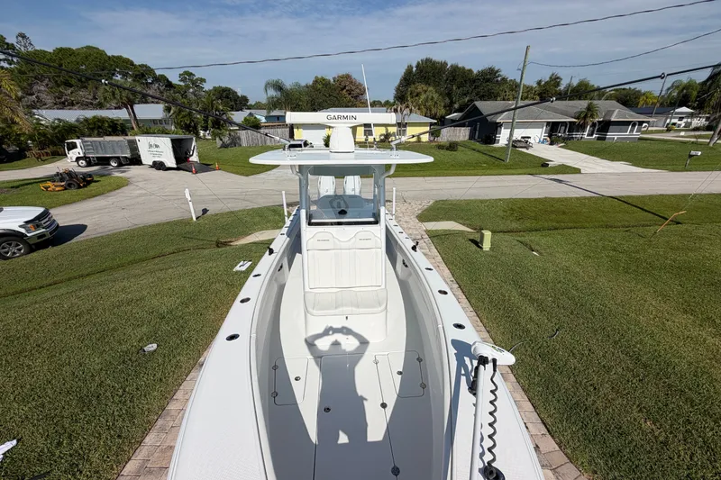 Slide: The Image of 2024 Bluewater BW 25T boat parked in a residential driveway, showcasing its sleek design. - 26
