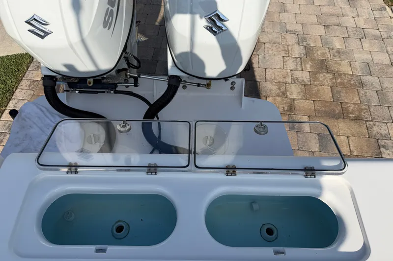 Slide: The Image of 2024 Bluewater BW 25T boat with dual Suzuki outboard engines and livewell compartments. - 24
