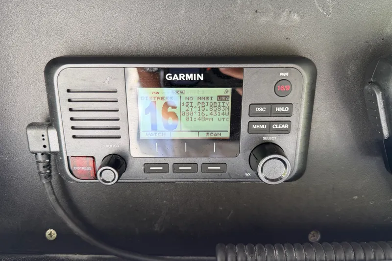 Slide: The Image of Garmin marine radio on 2024 Bluewater BW 25T boat dashboard, displaying distress channel. - 35
