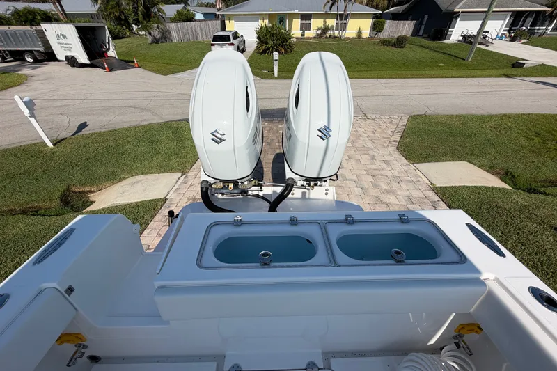 Slide: The Image of 2024 Bluewater BW 25T boat with dual Suzuki outboard engines, parked in a residential driveway. - 23