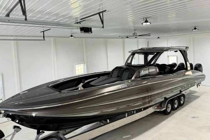 The Image of 2018 MTI V42 boat on trailer in a spacious indoor garage. - 0