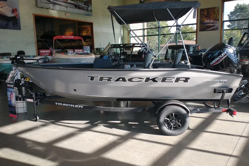 The Image of 2027 Tracker Pro Guide V-16 SC boat displayed indoors with Mercury engine. - 0