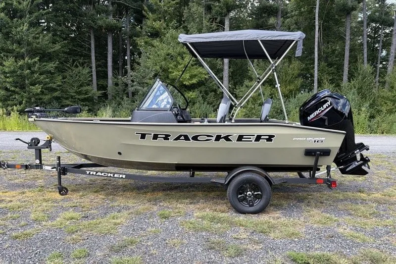 The Image of 2027 Tracker Pro Guide V-16 WT boat with canopy on trailer, parked outdoors. - 0