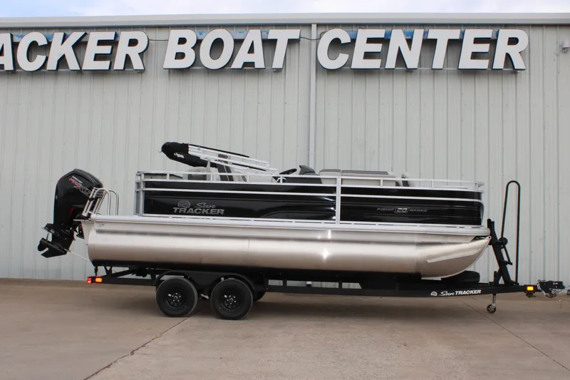 The Image of 2027 Sun Tracker Fishin' Barge 20 DLX pontoon boat on trailer at dealership. - 0