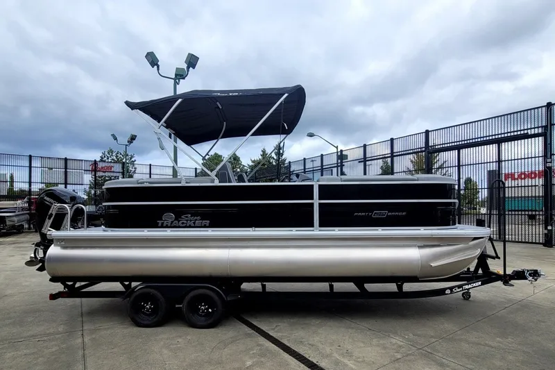 The Image of 2027 Sun Tracker Party Barge 22 DLX pontoon boat with canopy on trailer. - 0
