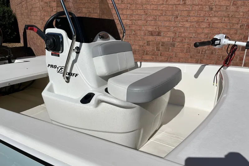 Slide: The Image of 2025 Mako Pro Skiff 13 CC boat interior with steering console and cushioned seat. - 7